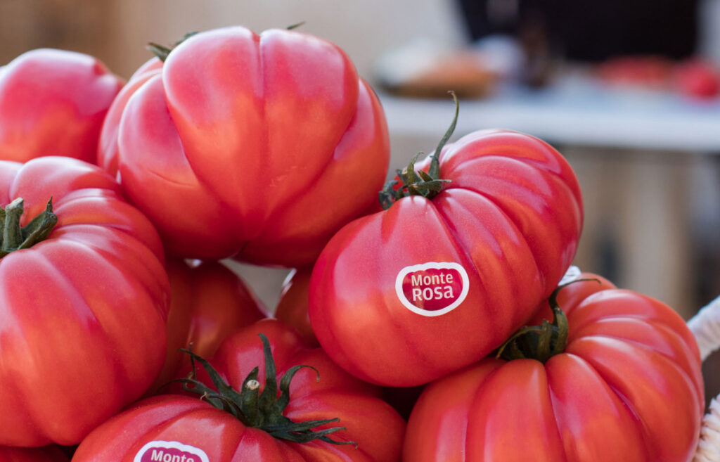 Tomates monterosa apilados unos encima de otros. Por su forma y color están muy apetecibles.